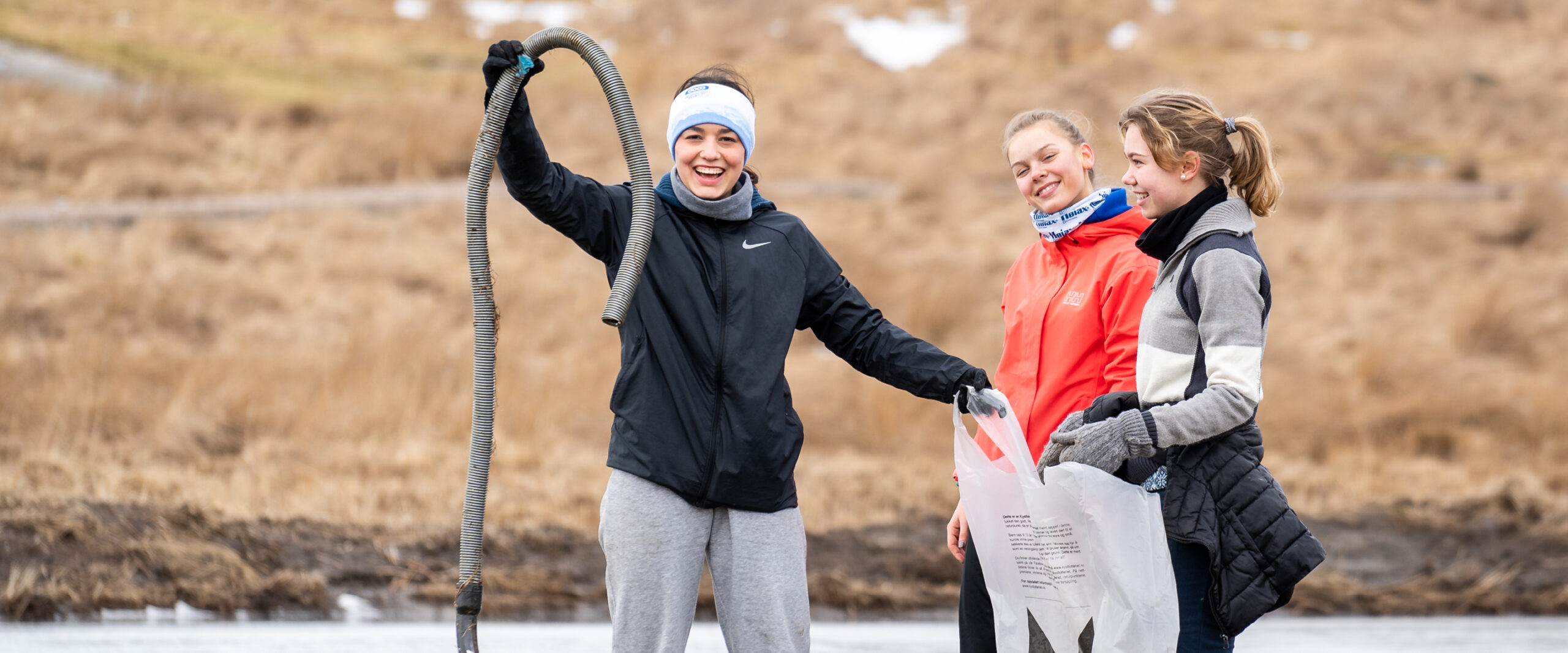 Unge jenter som driver med strandrydding,