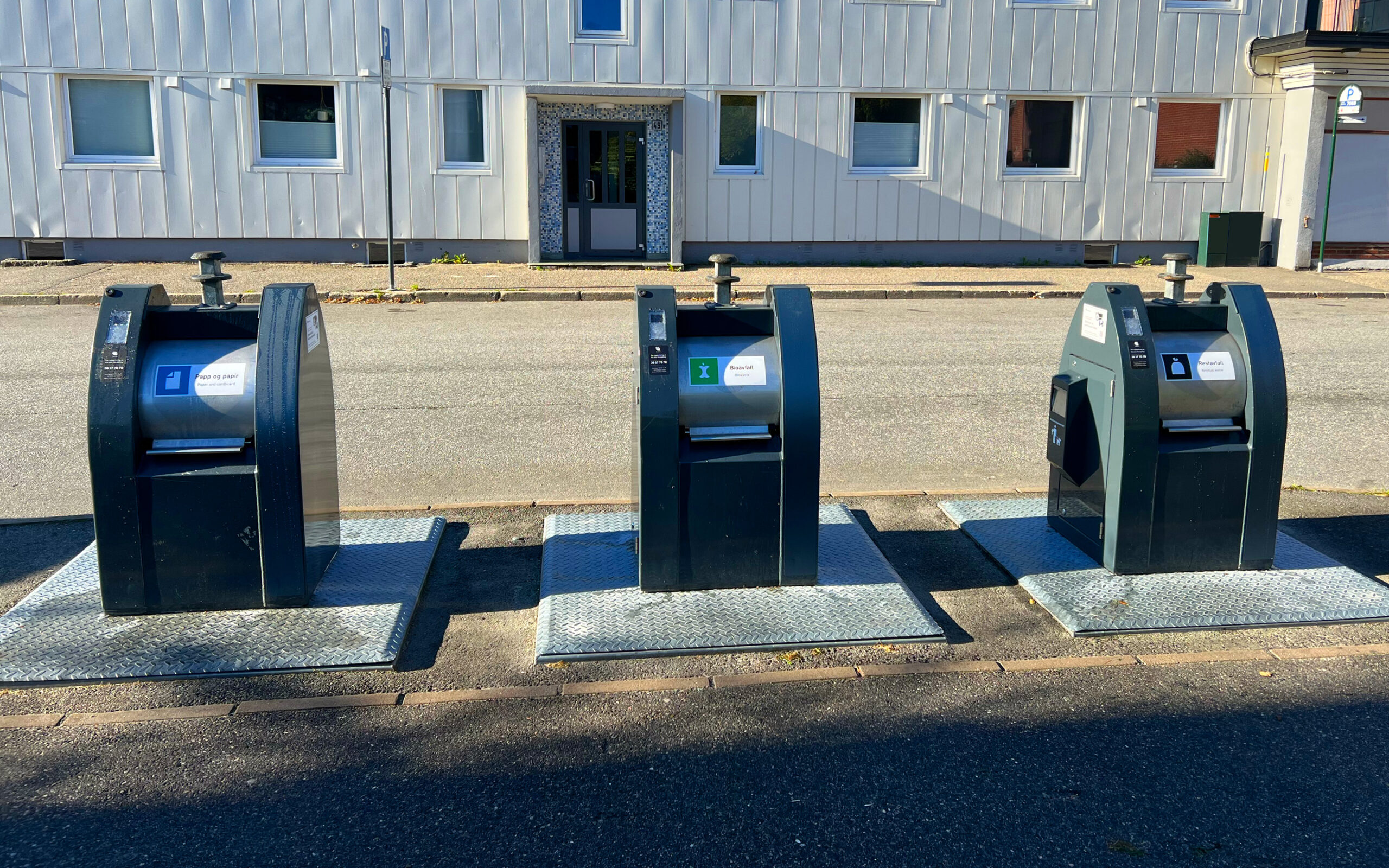 Tre nedgravde containere for papir og papp, bioavfall og restavfall.