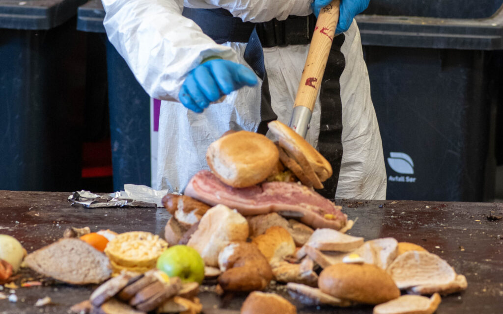 Medarbeider som spar opp store mengder spiselig mat som er funnet i forbindelse med sorteringsundersøkelse av restavfall og bioavfall.