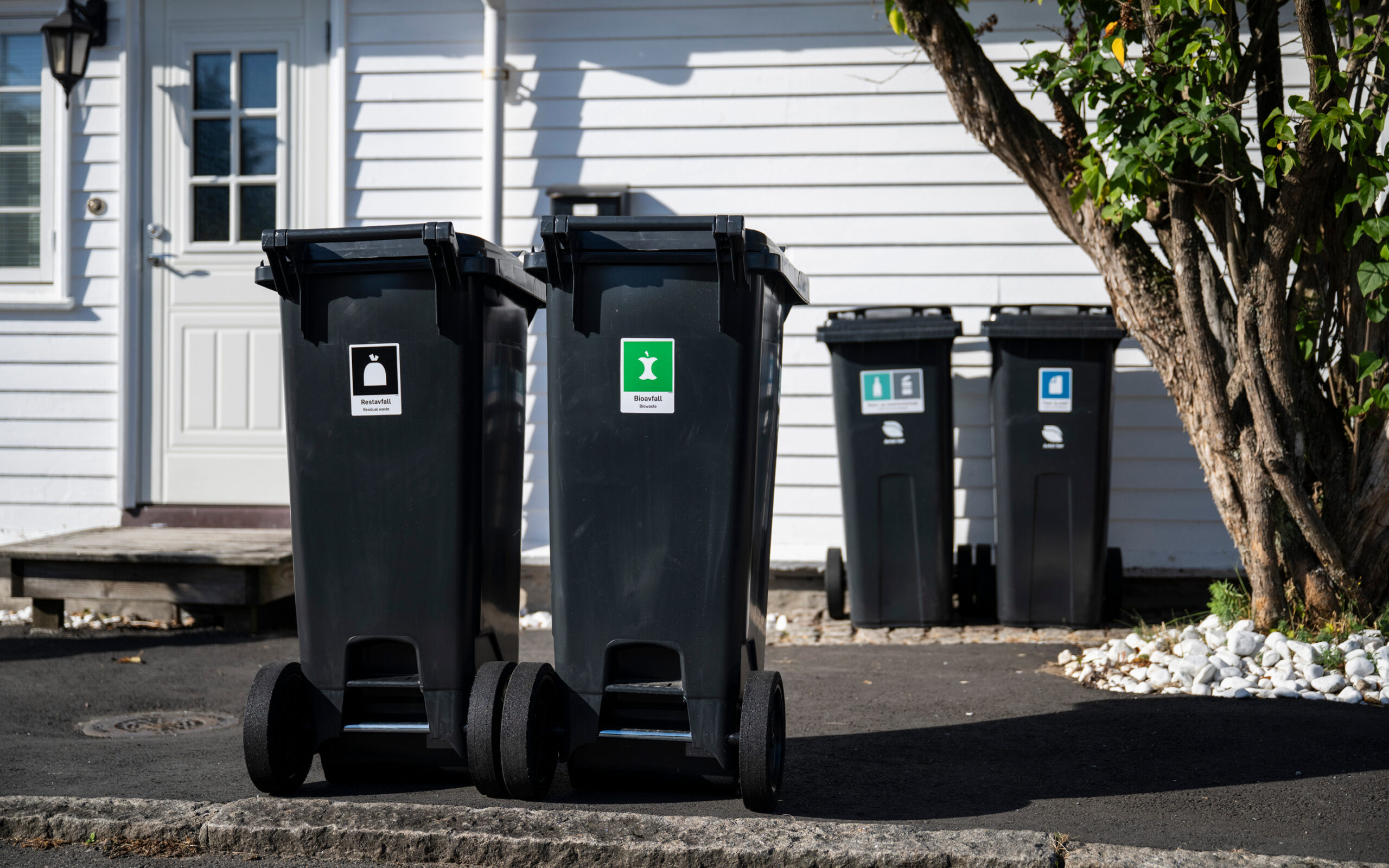 Avfallsdunker som er satt ut mot gate for tømming