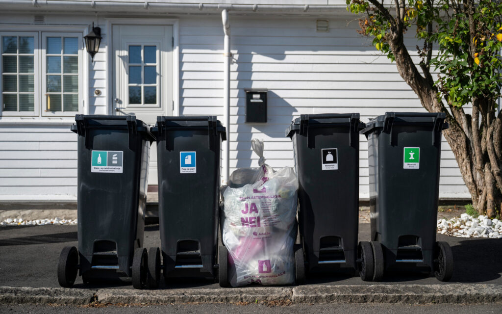 Avfallsdunker som er satt ut mot gate for tømming